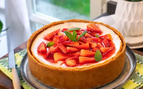 Cheesecake con mascarpone e fragole fresche, guarnita con menta. Un dolce invitante, perfetto per ogni occasione.