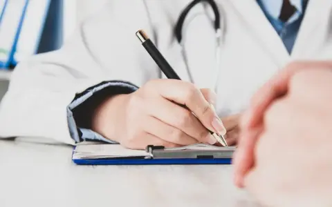 Lekarz pisze receptę, zastanawiając się, czy zwolnienie od psychiatry zostaje w papierach.