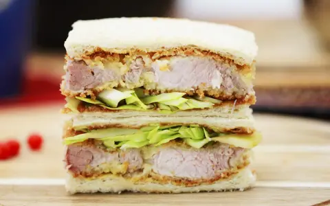 Ein saftiges Katsu Sando mit knusprigem Schnitzel, frischem Kohl und weichem Brot. Ein Genuss für jeden Feinschmecker!