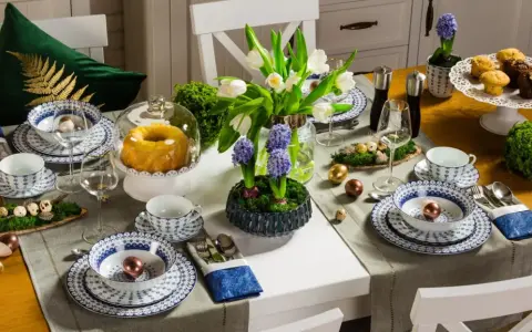 Stół wielkanocny inspiracje: białe tulipany, hiacynty, babka, babeczki, złote i miedziane jajka, porcelana z niebieskim wzorem.