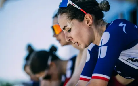 Juliette Labous, mit Pflaster auf der Stirn, konzentriert sich vor dem Rennen. Ihre Teamkolleginnen sind im Hintergrund zu sehen.