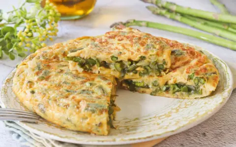 Tortilla de esparragos jugosa y dorada, con espárragos frescos y tiernos en su interior. Un plato delicioso y saludable.