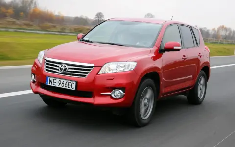 Czerwony SUV do 30 tys. na drodze, z widocznym grillem i tablicą rejestracyjną WE 966EC.