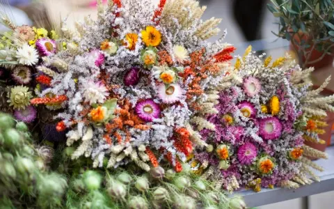 Bunte Sträuße mit getrockneten Blumen und Gräsern, die an einen Sommer voller blumen trocknen erinnern.