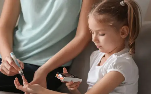 Mutter hilft Kind bei Blutzuckermessung. Ein wichtiger Teil im Leben mit diabetes kinder.
