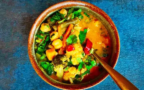 Miseczka tajskiego curry z warzywami, ciecierzycą i mlekiem kokosowym.