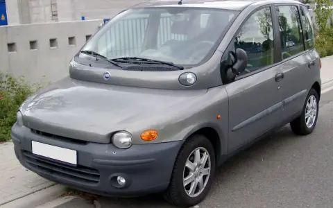 Szary Fiat Multipla, często uznawany za najbrzydsze auto na świecie, stoi na ulicy. Jego nietypowy kształt przyciąga wzrok.