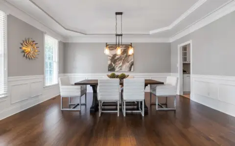 Comedor elegante con paredes y techo pintados del mismo color gris claro, creando un ambiente sereno.