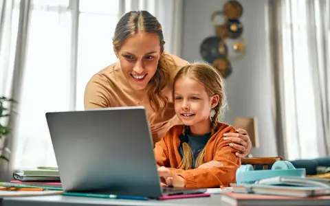 Mama pomaga córce w nauce online. Dni opieki na dziecko mogą być pełne wspólnych chwil przy komputerze.