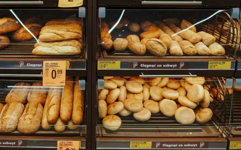 Różnorodne bułki i bagietki na półkach sklepowych. Idealne na śniadanie, choć warto sprawdzić ich kcal.