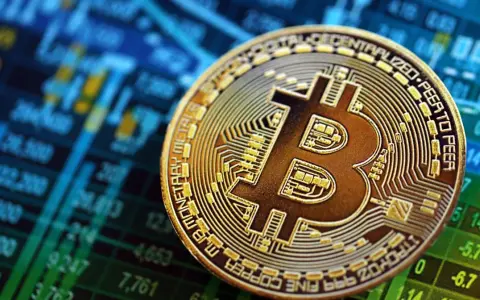 Złoty Bitcoin na tle wykresu giełdowego. To symbol tego, czym są kryptowaluty i jak działają.