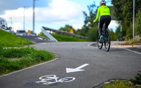 Kobieta na rowerze przemierza malownicze trasy rowerowe Kujawsko-Pomorskie.