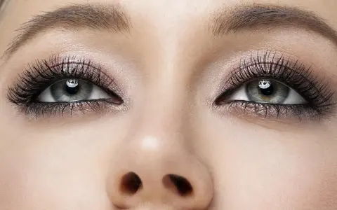 Oczy z makijażem typu smokey eyes, podkreślone długimi rzęsami i błyszczącym cieniem.
