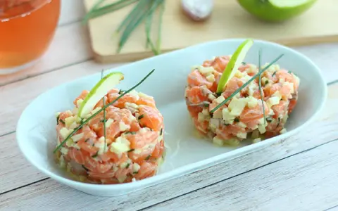 Deux tartares de saumon frais, garnis de dés de pomme verte et de ciboulette, parfaits pour une recette saumon fumé revisitée.