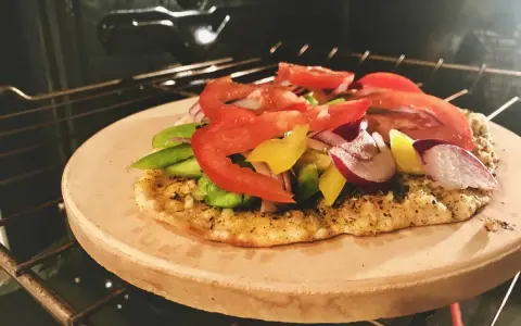 Pizza na kamieniu w piekarniku, z pomidorami, papryką i cebulą. Po pieczeniu dowiedz się, jak umyć kamień do pizzy.