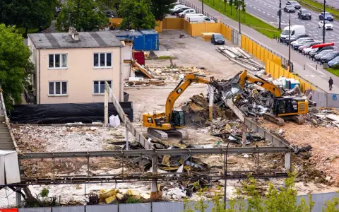 Dwa koparki pracują przy wyburzaniu budynku. Szacowany koszt wyburzenia domu 100m2 może być wysoki.
