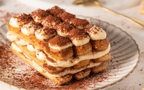 Pyszne tiramisu bez jajek, warstwowo ułożone biszkopty i krem, posypane kakao. Idealne na deser.