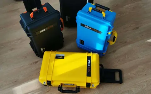 Trzy walizki Peli Air w kolorach czarnym, niebieskim i żółtym. Idealne do przewożenia cennego sprzętu w bagażu podręcznym.