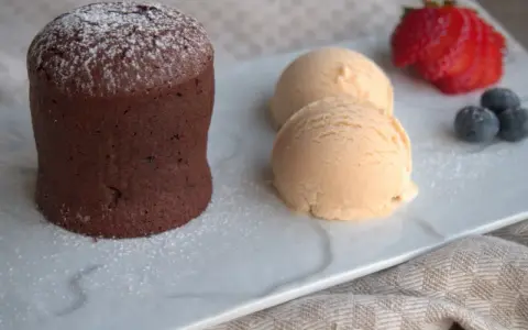 Delicioso coulant de avellana con helado cremoso, fresa y arándanos.