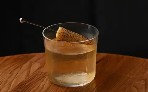 Szklanka z drinkiem i kawałkiem kukurydzy, intrygująca zapowiedź tego, jak smakuje brandy.
