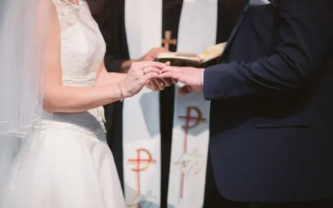 Para młoda wymienia obrączki podczas ceremonii ślubnej w kościele.