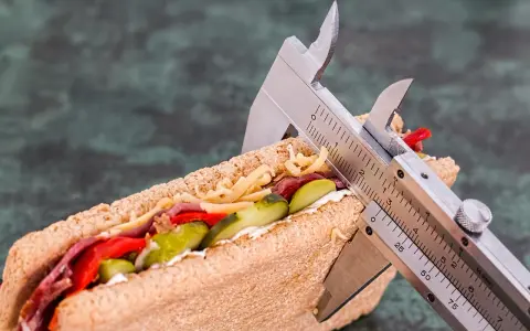 Kanapka z serem, mięsem i warzywami, mierzona suwmiarką. Wygląda na to, że ma duzo kcal.