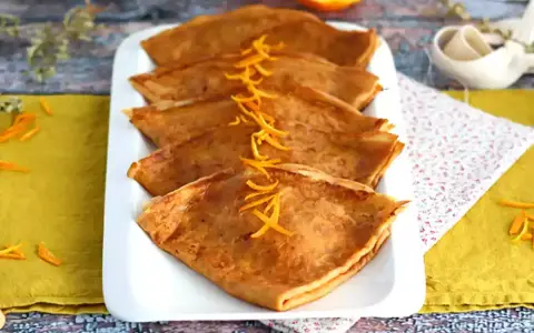 Färdigstekta crêpes, vikta och prydda med apelsinskal. Ett perfekt crepes recept för en härlig frukost eller dessert.