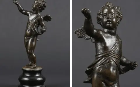 Brązowy putto z uskrzydlonymi plecami, w pozie gestykulacji, na ciemnym tle.