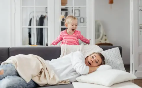 Niña emocionada sobre el sofá, mientras su madre se asusta. ¡Un día típico con el horario para niños en casa!