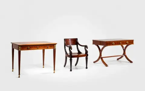 Trois meubles en bois sombre, dont deux tables fines et une chaise ornée de têtes de cygne, évoquant le style Louis XV.