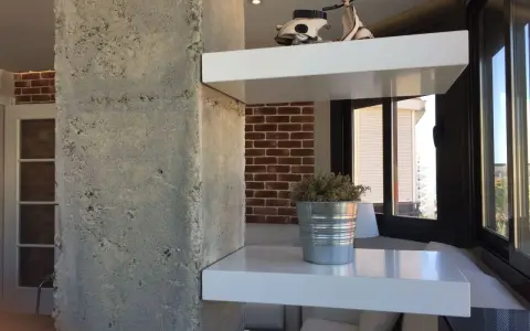 Ideas para decorar una columna en el salón: estantes blancos con Vespa y planta, ladrillo visto y hormigón.