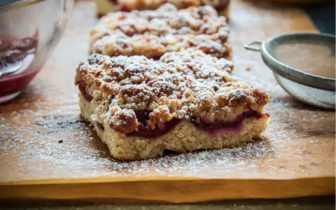 Saftiger Pflaumenkuchen vom Blech, bestäubt mit Puderzucker. Ein köstliches Rezept für den Herbst.