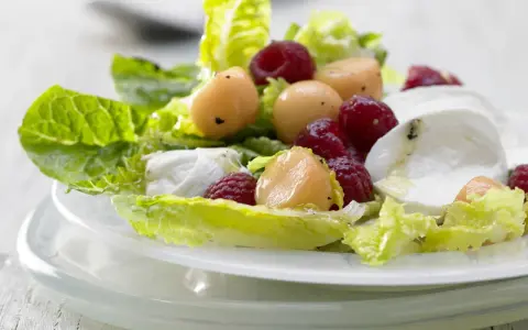 Erfrischender melonensalat mit mozzarella, Himbeeren und knackigem Salat. Ein leichter Genuss für warme Tage.