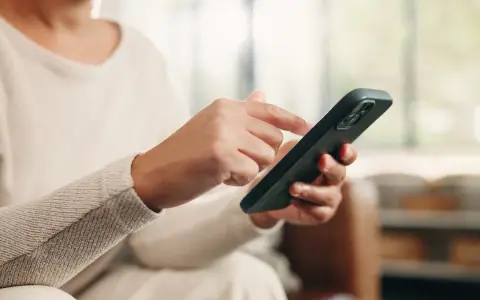Dłoń z telefonem, przygotowująca się do wykonania czynności, jak przenieść dane z telefonu na telefon.