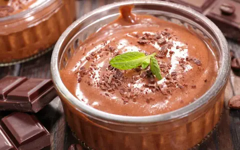 Mousse au chocolat Marie Morin recette : un délice onctueux, garni de copeaux de chocolat et d'une feuille de menthe, prêt à être dégusté.