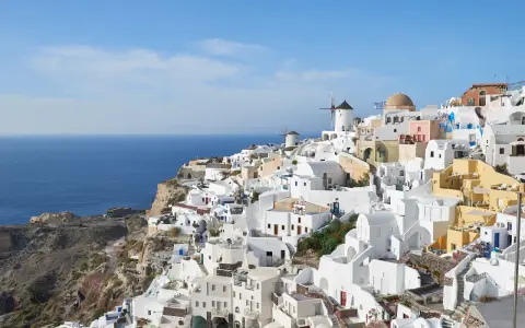Widok na białe domy i wiatraki na klifie nad morzem, Santorini.