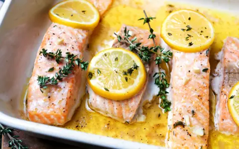 Saftiger Lachs im Ofen, garniert mit Zitronenscheiben und frischem Thymian, bereit zum Genießen.