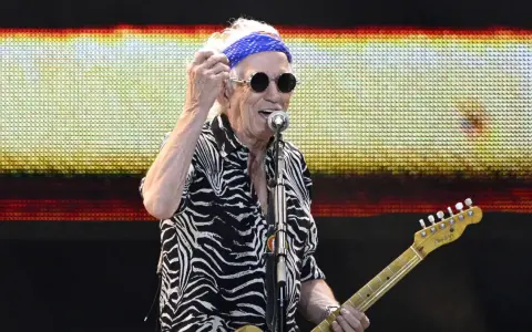 Keith Richards heute, mit blauem Bandana und Sonnenbrille, spielt Gitarre auf der Bühne.