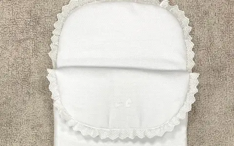 Patrón saco bebé capazo blanco con encaje y iniciales GG bordadas. Perfecto para un dulce descanso.