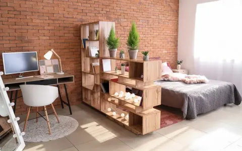 Étagère modulable en bois pour séparer une pièce en deux sans travaux, créant un espace bureau et un coin nuit.