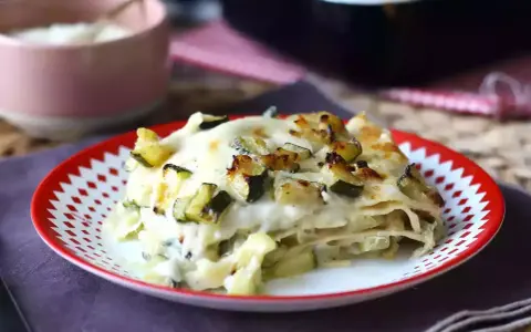 En portion krämig vegetarisk lasagne med zucchini, toppad med gyllene ost.