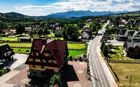 Malownicze tatrzańskie miejscowości z charakterystyczną architekturą i górami w tle.