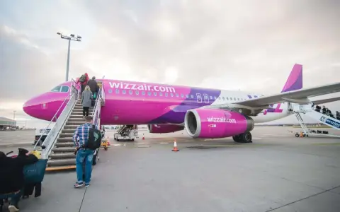Pasażerowie wsiadają do różowego samolotu Wizzair. Czy można odwołać lot?