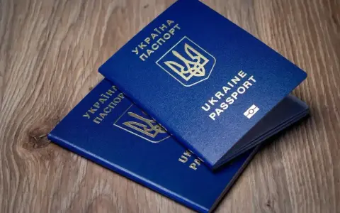 Dwa niebieskie paszporty Ukrainy leżą na drewnianym blacie. Czy wystarczą na podróż do Turcji, czy potrzebny jest dowód osobisty?