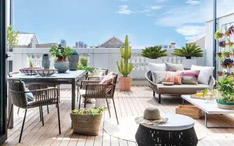 Ideas para decorar una terraza: mesa, sillas, sofá, plantas y cestas crean un espacio acogedor y moderno.