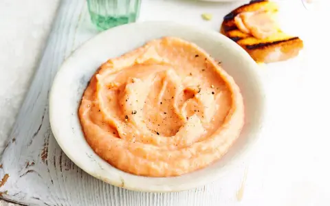 Cremiger, rosafarbener Dip mit Pfeffer bestreut, perfekt als schneller Dip zu Kartoffeln. Daneben ein geröstetes Brot mit Lachs.