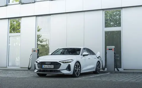 Ein weißer Audi lädt an einer Ladestation. Das zeigt, was ist ein Hybridauto: flexibel und umweltfreundlich unterwegs.
