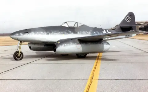 Ein deutscher Jet, die Messerschmitt Me 262, steht auf einem Rollfeld.