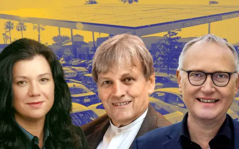 Drei Personen vor einer Solaranlage, die auf einem Parkplatz mit Autos installiert ist. Ein Symbol für die Zukunft der **Energie USA**.