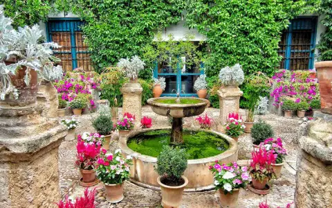 Cortile fiorito con fontana, ideale dove andare in primavera per ammirare la bellezza della natura.